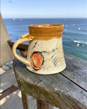 handmade ceramic mug with sand-textured glaze and warm rim