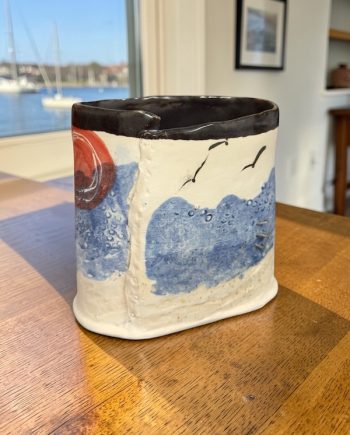 handmade vase with sunset, birds, retaining walls sitting on a table