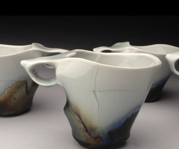 Porcelain cup with integrated sculptural finger-loop handle.