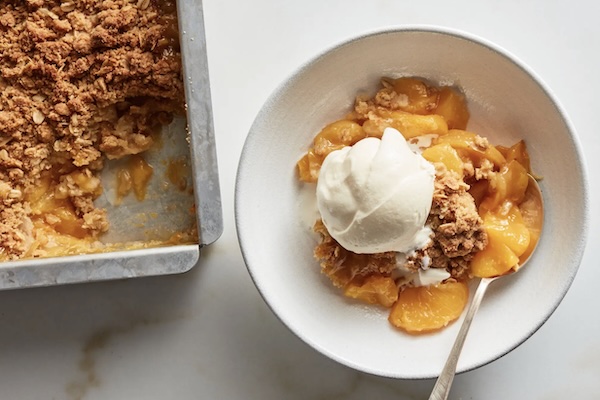 peach crisp out of the oven and in a bowl ready for eating
